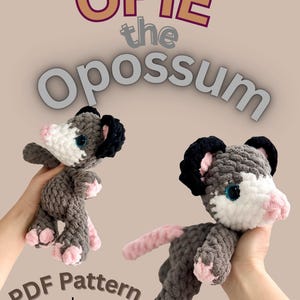 Puede incluir: Dos peluches de zarigüeya de ganchillo, uno de pie y otro posando, con cuerpos grises, caras blancas, narices y pies rosas y orejas negras. Se muestra el texto "Opie the Opossum" y "PDF Pattern by Snuggle_plush".