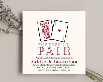 Könnte beinhalten: Quadratische Verlobungsankündigung mit zwei Spielkarten, eine mit einer roten Königin und den Worten "Lucky You", die andere mit einem roten Herz. Der Text "The Perfect Pair" ist in einer dekorativen Schriftart gehalten, mit Namen und Veranstaltungsdetails darunter.