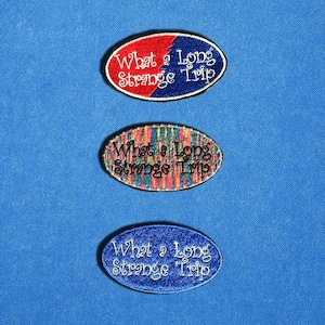 May include: Three embroidered patches with the text "What a Long Strange Trip" in a script font. The top patch is red and blue, the middle patch is multicolored, and the bottom patch is blue.