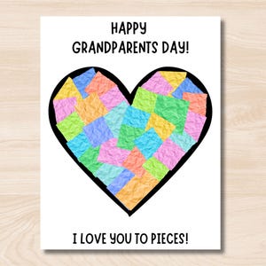 以下が含まれることがあります： カラフルな紙の正方形で満たされた黒いハートが付いた白いカード。「Happy Grandparents Day!」と「I Love You to Pieces!」と書かれています。