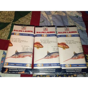 May include: Three rolls of Ralph Lauren coordinated decorative wallcovering borders featuring illustrations of yellow perch and swordfish. Each roll is white with blue horizontal stripes and measures 5 yards by 6.83 inches or 4.57 meters by 17.35 cm.