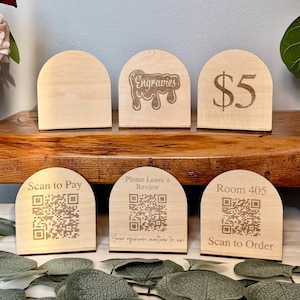 May include: Six wooden arched signs with engraved designs. The signs feature text and QR codes. The text includes "Engravies", "$5", "Scan to Pay", "Please Leave a Review", "Room 405", "Scan to Order", and "Your opinion matters to us!"