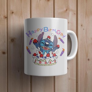 May include: White ceramic mug featuring a blue cartoon character, Stitch, celebrating a birthday with a cake and candles. The text "Happy Birthday" is written in rainbow colours around the character.