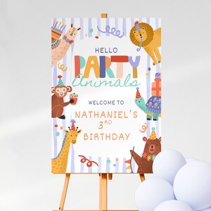 Może przedstawiać: Znak na przyjęcie urodzinowe na sztaludze z napisem "Hello Party Animals" i "Witamy na 3. urodzinach Nathanaela". Znak przedstawia zwierzęta z kreskówek, w tym lwa, małpę, żyrafę i niedźwiedzia, wszystkie w czapkach imprezowych.