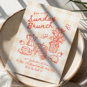 May include: A rectangular invitation card with a beige gingham pattern featuring red line art illustrations of a moka pot, pancakes, a teacup, a vase of flowers, butterflies, strawberries, and a croissant. Text reads: Join us for Sunday Brunch, 25th September at 10am, Le Cafe, 123 Anywhere St, Any City, Rsvp by Sept 15.