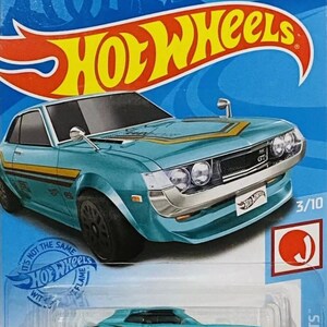 May include: A blue 1970 Toyota Celica Hot Wheels die-cast car with black wheels and gold accents. The car is on a blue and white card with the Hot Wheels logo and the text 'HW J-IMPORTS' and '70 TOYOTA CELICA'.