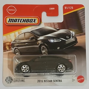 May include: A Matchbox die-cast model of a 2016 Nissan Sentra sedan. The black car is displayed on a red and yellow card with the Nissan and Matchbox logos. The card also includes the text "91/125" and "Designed for a Lifetime."