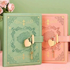 May include: Two decorative journals with heart-shaped locks. One journal is mint green, the other is coral. Both have gold accents and floral designs. Each journal has a matching key attached to the lock.