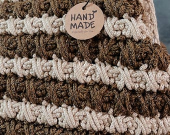 Könnte beinhalten: Eine braune und beige gehäkelte Tasche mit einem braunen Etikett, auf dem "HAND MADE" und "Especially for You" steht.