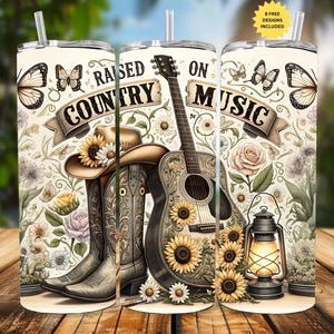 May include: Three stainless steel insulated tumblers with lids and straws. The tumblers feature a country music theme with a guitar, cowboy boots, a hat, sunflowers, and the text "RAISED ON COUNTRY MUSIC". The design includes butterflies and floral elements.