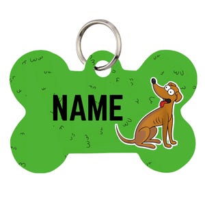May include: A bone-shaped pet ID tag in bright green with a repeating black grass-like pattern. The word NAME is printed in large black capital letters in the center. A cartoon brown dog with a red tongue sits on the right, and a silver ring is attached.
