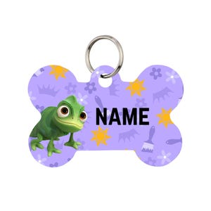 May include: A bone-shaped pet tag with a purple background featuring a green chameleon, yellow suns, and the word "NAME" in black. The tag has a silver ring for attachment.