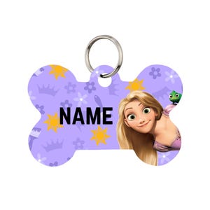 May include: A bone-shaped pet tag with a purple background featuring a pattern of crowns, flowers, and suns. The tag has the word "NAME" in black block letters. A cartoon image of a blonde princess and a green chameleon is on the right side of the tag.