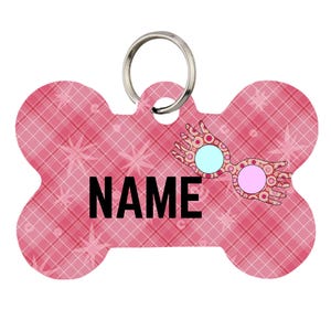Può includere: Una medaglietta per animali a forma di osso con sfondo a quadri rosa e motivi a stella. La parola NAME è stampata in grassetto nero in maiuscolo al centro. A destra, un grafico di occhiali rotondi con lenti azzurre e rosa.