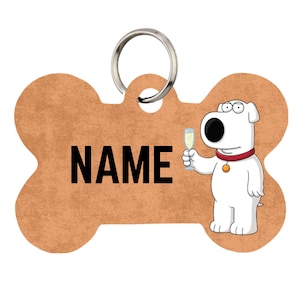 Op de afbeelding: Een botvormig huisdierpenning met een bruin, getextureerd oppervlak met het woord NAME in dikke zwarte letters. Een witte cartoonhond met een rode halsband en een gouden penning houdt een glas champagne vast. Een zilveren metalen ring zit aan de bovenkant.