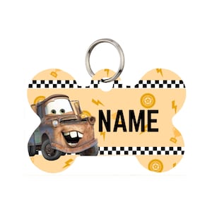 May include: Bone-shaped pet tag featuring a cartoon image of Mater from the movie Cars. The tag is light orange with a repeating pattern of lightning bolts and racing wheels. The word "NAME" is printed in bold black letters.