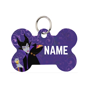 May include: Bone-shaped pet tag with a purple background and a cartoon image of a character with black horns and a black crow. The tag has the word "NAME" in white block letters and a silver ring for attachment.