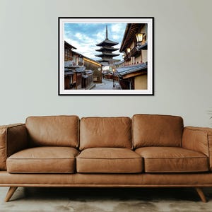 May include: A photograph of a traditional Japanese pagoda in a narrow street lined with buildings. The pagoda is a five-storey structure with a distinctive curved roof. The street is lined with traditional Japanese buildings with wooden facades and tiled roofs. The image is taken from a low angle, looking up at the pagoda.