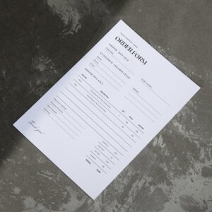 Pode incluir: Um formulário de pedido branco com texto preto, incluindo "ORDER FORM" e "ORDER DETAILS". O formulário tem seções para detalhes do cliente e do pedido, com um "Thank you!" escrito à mão na parte inferior.