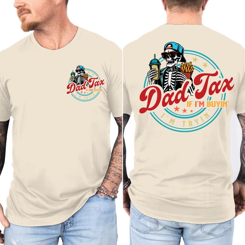 May include: Cream-colored t-shirt featuring a skeleton wearing sunglasses and a blue cap, holding a drink and fries. The text "Dad Tax" is in red script, with "If I'm buyin'" and "I'm tryin" in smaller text.