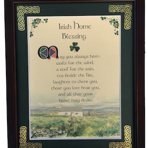 May include: A framed print with a green background and gold Celtic knot borders. The print features a traditional Irish blessing in calligraphy with an illustration of a cottage in a green field.