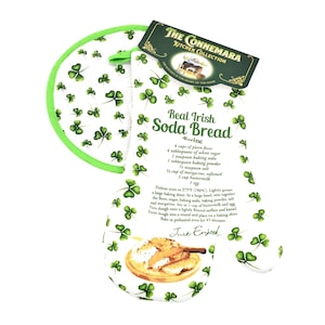 May include: White oven mitt and pot holder set with a green shamrock pattern. The mitt features a recipe for Real Irish Soda Bread. The pot holder has a green trim. The set is from The Connemara Kitchen Collection.