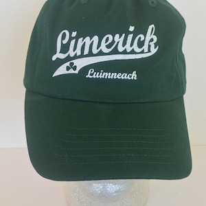 May include: A green baseball cap with a white embroidered logo that says "Limerick" with a shamrock and "Limerick" in Irish Gaelic.