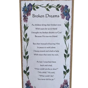 Puede incluir: Un letrero de madera con un poema sobre sueños rotos. El letrero está decorado con flores moradas y rosas y hojas verdes. El poema dice: "Como los niños traen sus juguetes rotos Con lágrimas para que los reparemos Traje mis sueños rotos a Dios Porque Él era mi amigo. Pero luego, en lugar de dejarlo En paz para trabajar solo Me quedé dando vueltas y traté de ayudar Con maneras que eran las mías. Al final, los arrebaté y lloré, "¿Cómo pudiste ser tan lento?" "Mi niño", dijo Él, "¿Qué podía hacer? Nunca me dejaste ir."