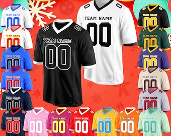 May include: A selection of American football jerseys in diverse colours, such as black, white, blue, and pink. Each jersey displays the text "TEAM NAME" and the number "00" in bold lettering. The jerseys have a V-neck design and are set against a festive red backdrop.