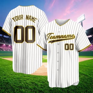 May include: A white baseball jersey with thin black pinstripes, featuring brown and yellow lettering that reads "YOUR NAME" and "00" on the back, and "Teamname" with "00" on the front. The button-down shirt has short sleeves with yellow trim.