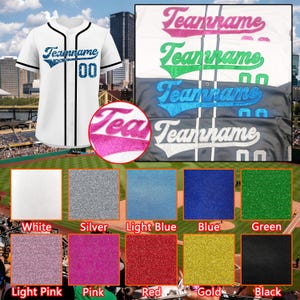 May include: A white baseball jersey with black trim, featuring the text Teamname and the number 00 in blue glitter. The image displays various color options for the text and numbers, including pink, green, blue, and white glitter finishes.