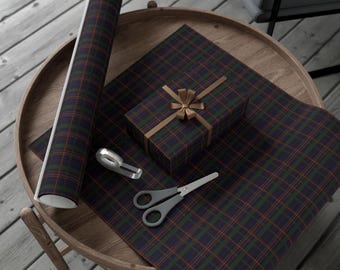 May include: A round wooden table displays gift-wrapping supplies. A wrapped box with a gold bow sits on plaid wrapping paper. A roll of matching paper, scissors, and tape dispenser are also on the table. The plaid pattern features navy, green, and orange.