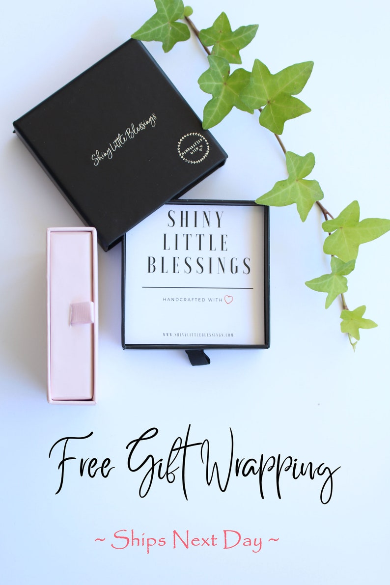 K&ouml;nnte beinhalten: Eine schwarze Box mit dem Text "Shiny Little Blessings" und eine rosa Box mit einem Band. Der Text "Free Gift Wrapping ~ Ships Next Day ~" steht unter den Boxen.
