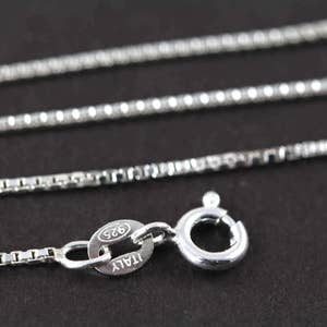 May include: A silver chain necklace with a lobster clasp and a tag that reads "925 ITALY".