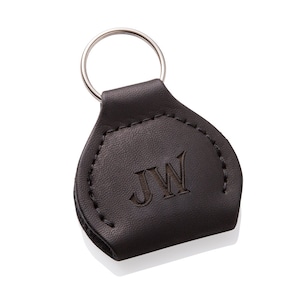 May include: A brown leather keychain with a silver key ring. The keychain has the initials "JW" embossed on the front.