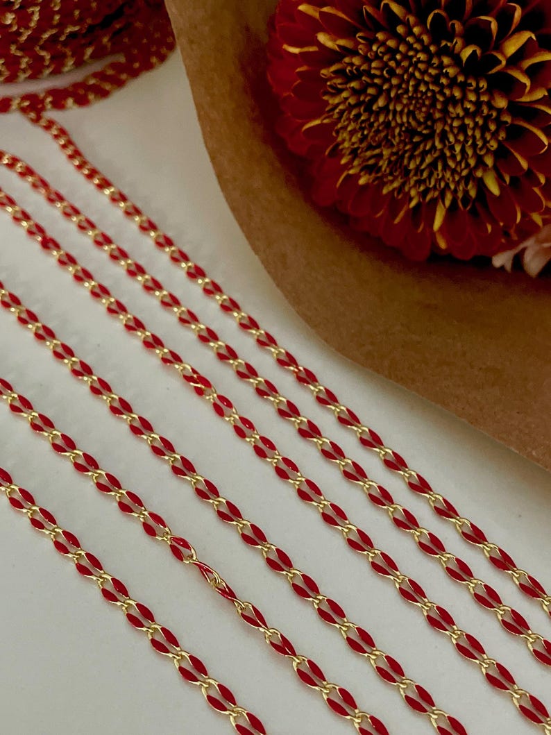 May include: Four strands of red and gold chain, with the red enamel on the outside of the chain links.