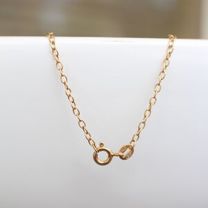 May include: A gold chain necklace with a lobster clasp closure. The clasp is marked with "14K" and "585".