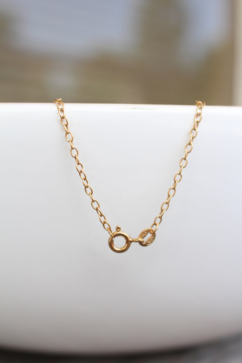 May include: A gold chain necklace with a lobster clasp closure. The clasp is marked with "14K" and "585".