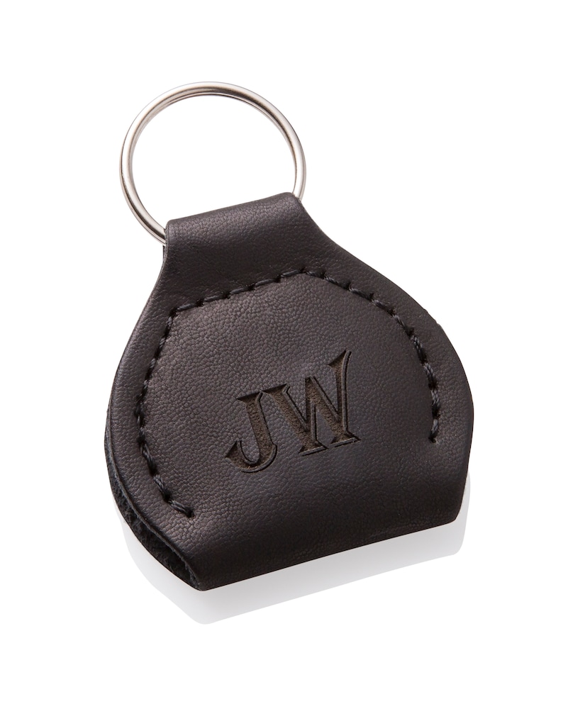 May include: Black leather keychain with a silver key ring and the initials "JW" embossed on the front.