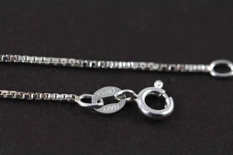 May include: A silver chain necklace with a lobster clasp and a tag that reads "ITALY 925".