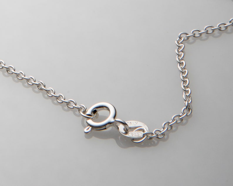 Puede incluir: Un collar de cadena de plata con un cierre de langosta y una etiqueta que dice "ITALY 925".