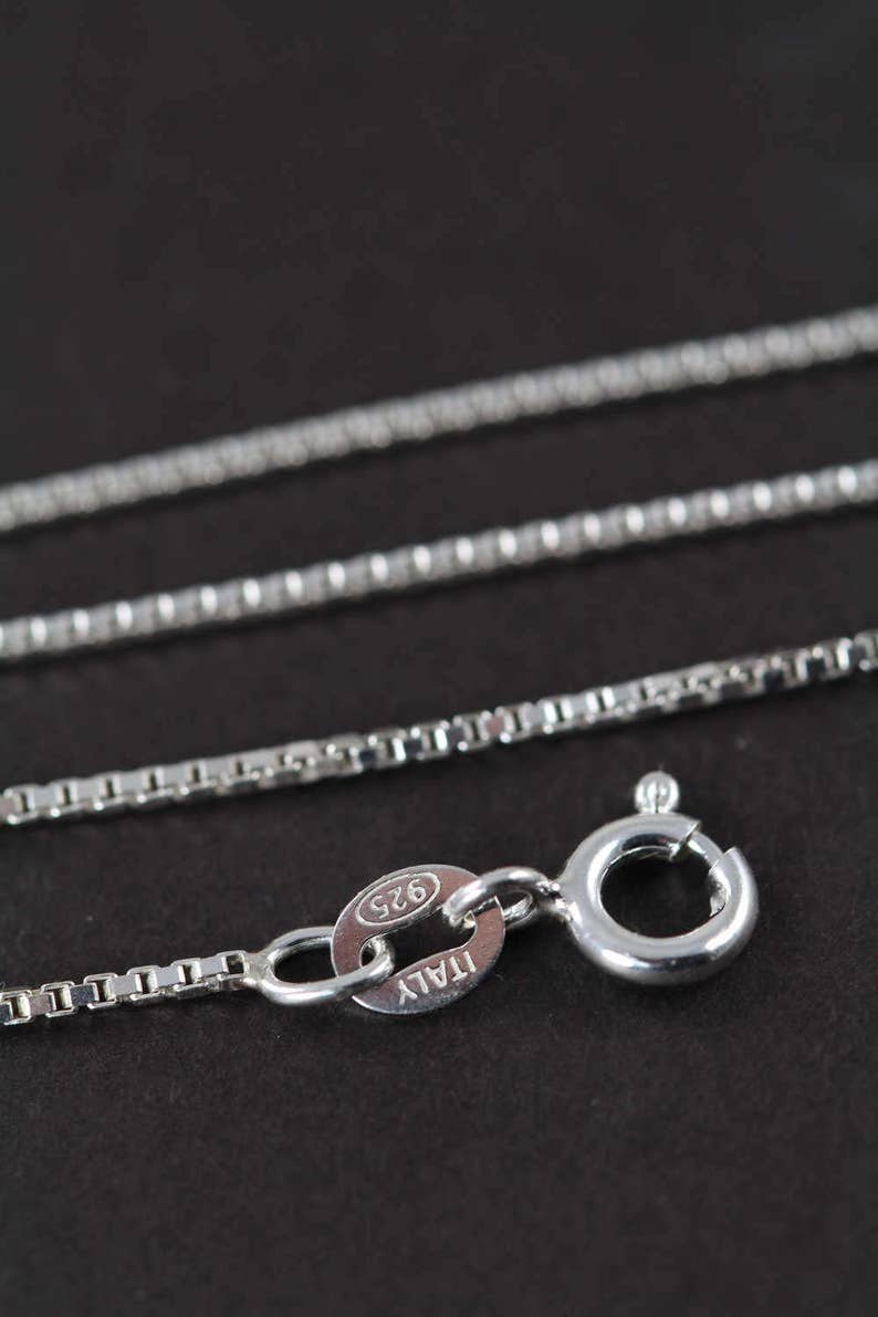 May include: A silver chain necklace with a lobster clasp and a tag that reads "ITALY 925".