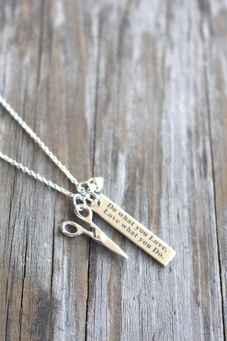 May include: Silver necklace with a pair of scissors charm and a rectangular tag that reads "Do what you Love, Love what you Do."