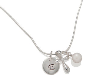 May include: Silver necklace with a cross charm, a pearl charm, and a round charm with the letter 'E' engraved on it.