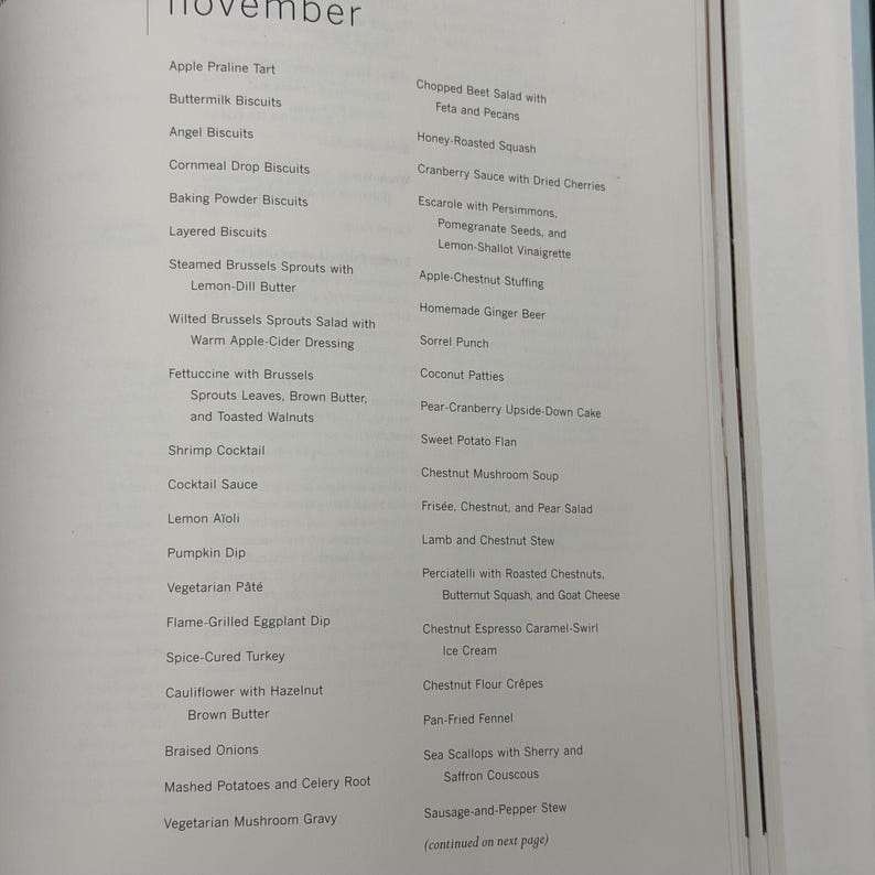 May include: A page from a cookbook featuring a list of recipes for the month of November. The recipes include dishes like Apple Praline Tart, Shrimp Cocktail, and Chestnut Mushroom Soup. The text is in black font.