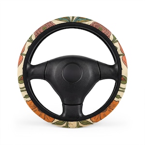 May include: A black steering wheel cover featuring a cream-coloured background with a repeating floral pattern. The design includes stylised orange and pink flowers with green leaves and stems arranged in a symmetrical, botanical layout.