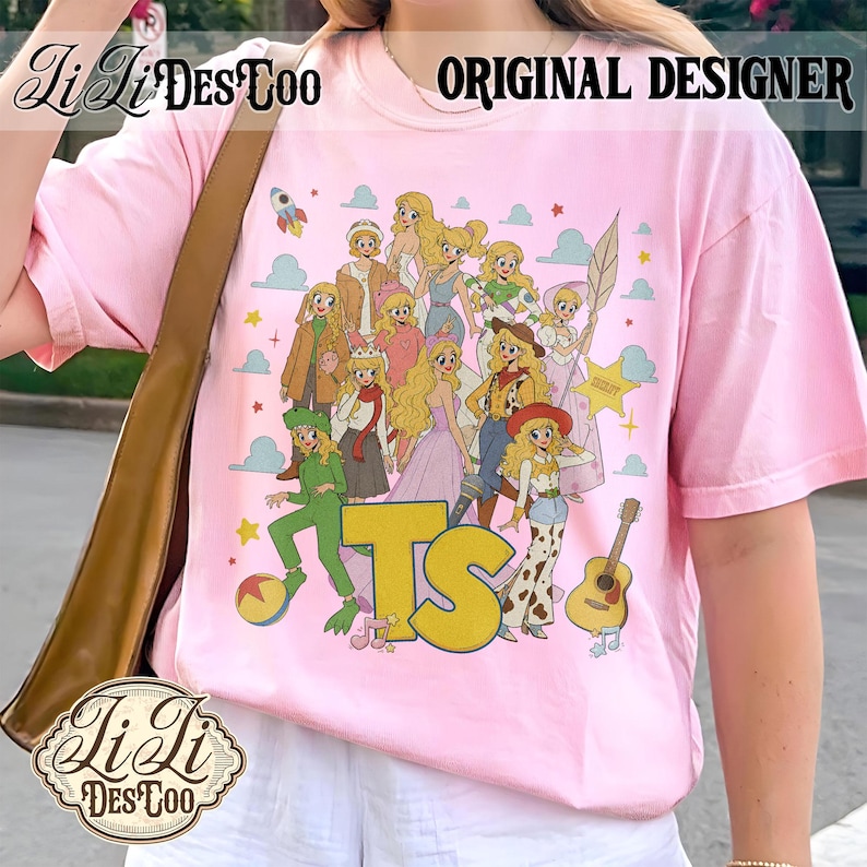 May include: A light pink t-shirt featuring a graphic print of multiple blonde characters in various outfits, including a green suit, a cowboy hat, and a crown. The design includes the yellow letters TS, a guitar, a ball, and clouds.