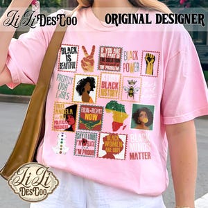 May include: A light pink t-shirt featuring a grid of postage stamp-style graphics with various slogans and illustrations, including text like Black Is Beautiful, Black Power, Study Black History, Equal Rights Now, and Black Women Are Dope.
