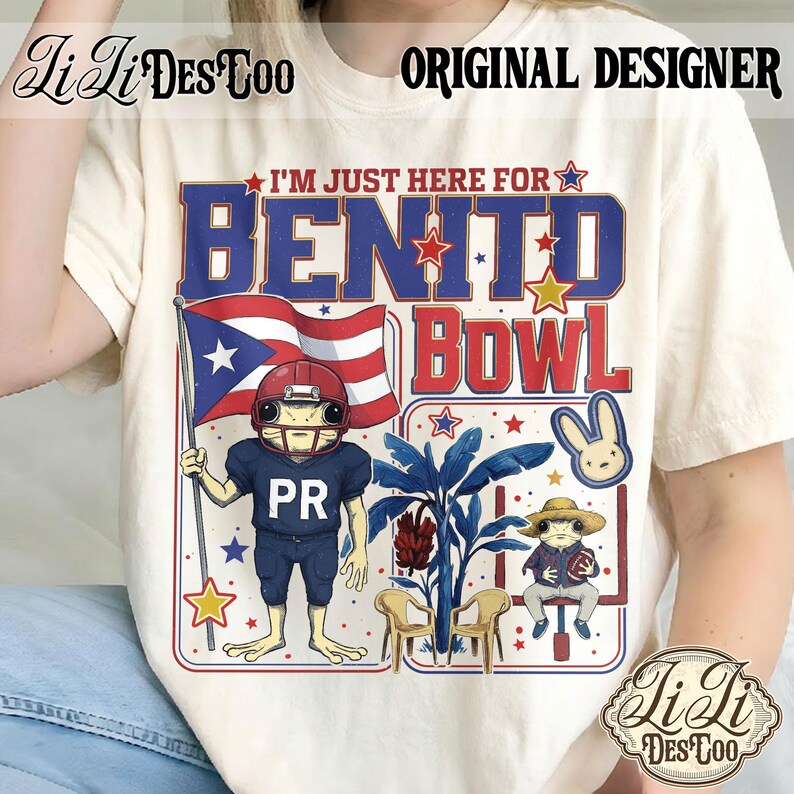 May include: Cream-colored t-shirt with a graphic design featuring the text "I'M JUST HERE FOR BENITO BOWL". The design includes a frog in a football uniform holding a Puerto Rican flag, and other cartoon elements. The shirt also has the text "PR".