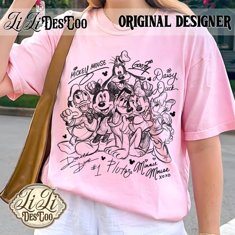 May include: A light pink t-shirt featuring a black and white sketch of Mickey Mouse, Minnie Mouse, Donald Duck, Daisy Duck, Goofy, and Pluto. The shirt has the text "MICKEY MOUSE" and "ORIGINAL DESIGNER".
